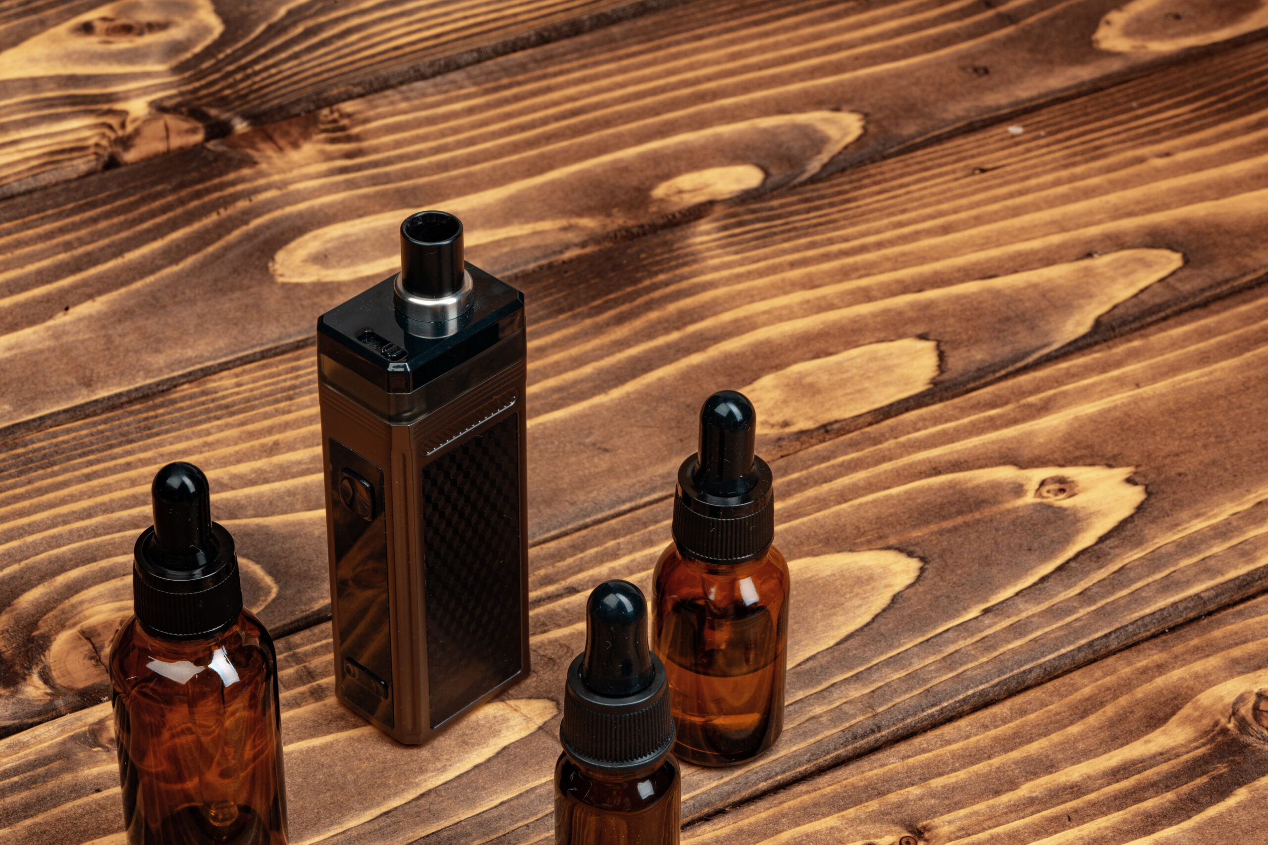 vape and vape juice bottles on brown wooden backgr 2026 01 08 22 41 08 utc
