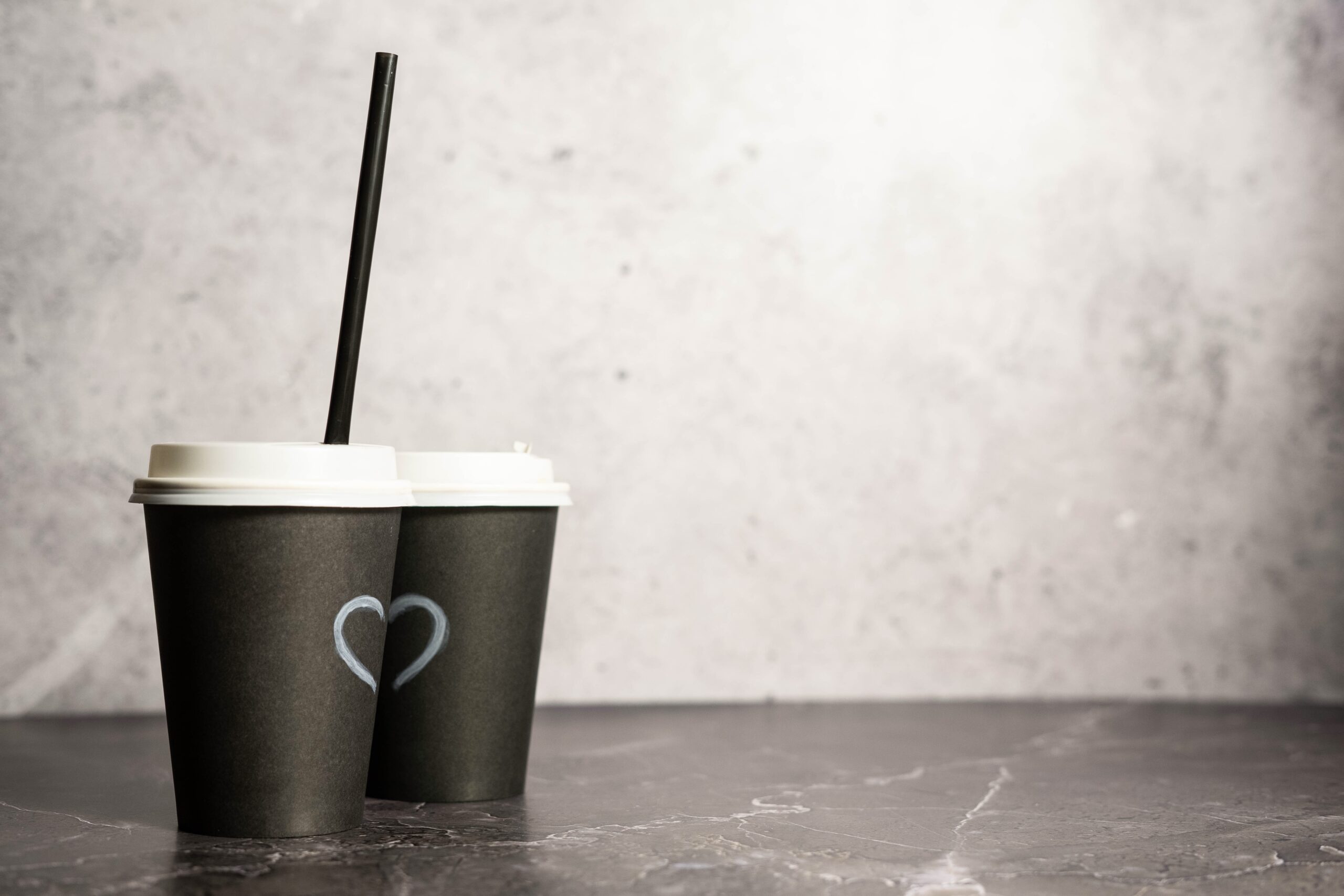 two paper cups with coffee on a black background 2026 03 13 05 40 30 utc