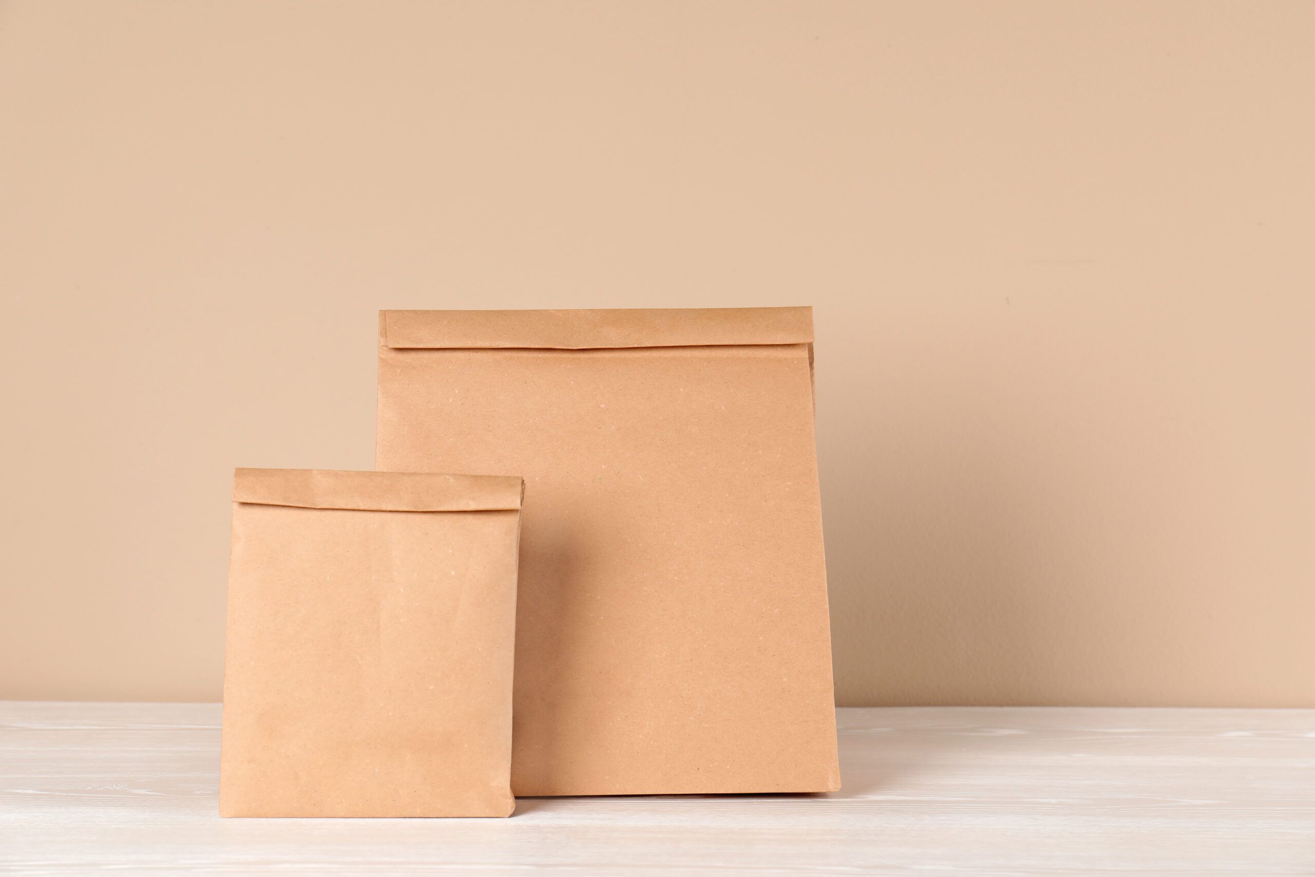 two tan paper bags on a white surface 2026 03 08 23 04 37 utc