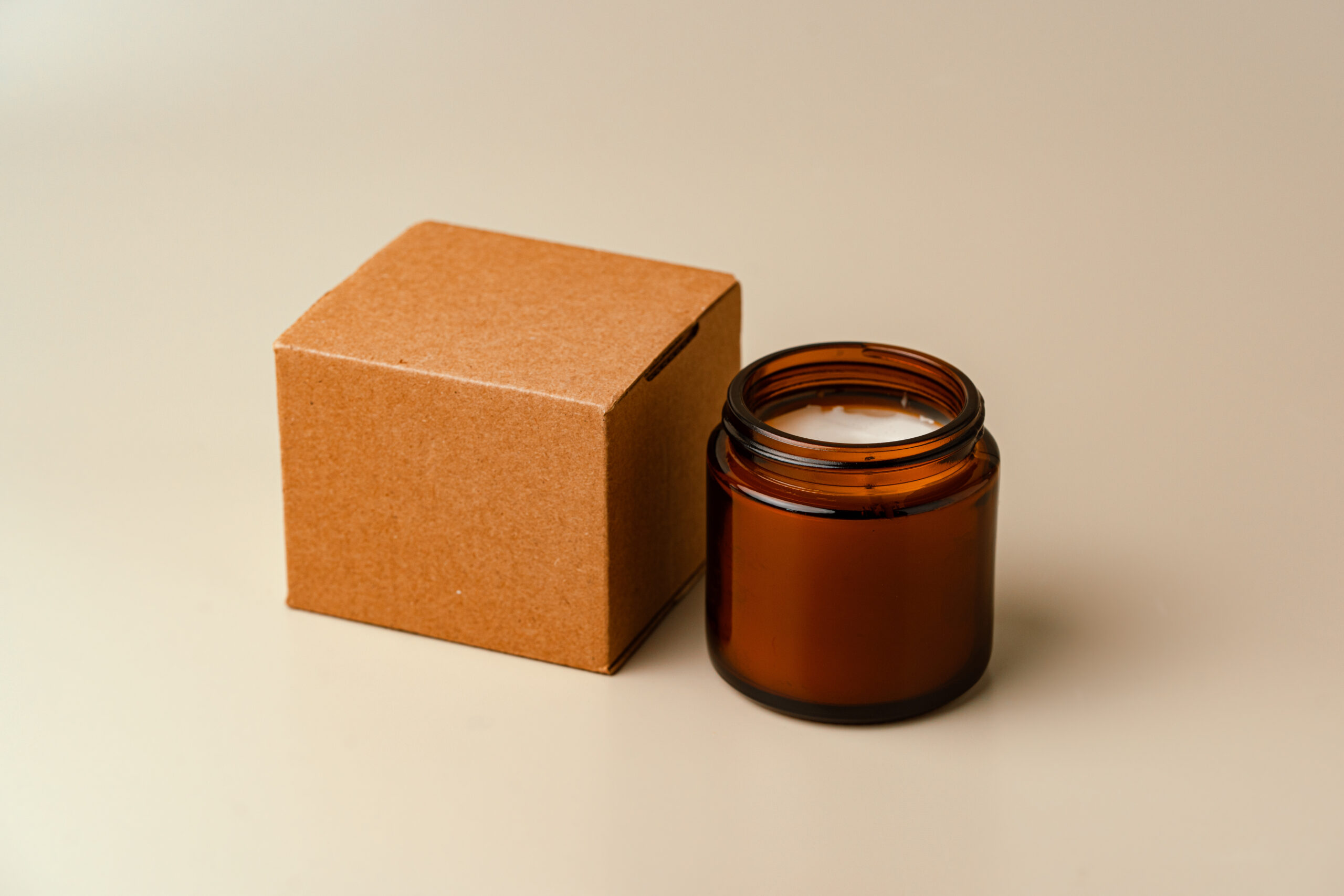 glass candle jar and cardboard box on beige backgr 2026 01 08 05 56 29 utc