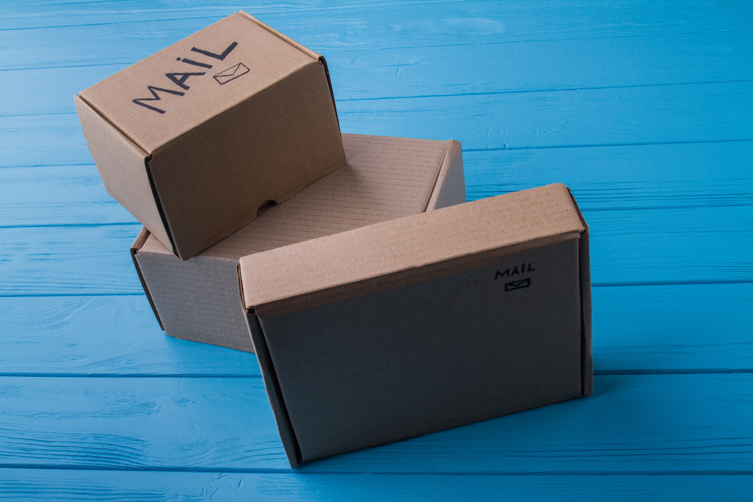 cardboard mail boxes on blue wooden background 2026 03 09 05 39 56 utc