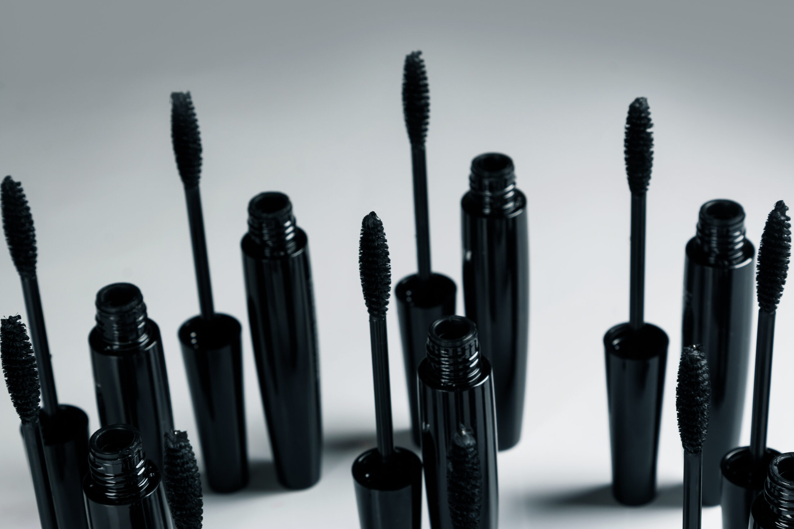 black mascara brushes and containers on gray backg 2026 01 05 05 08 04 utc