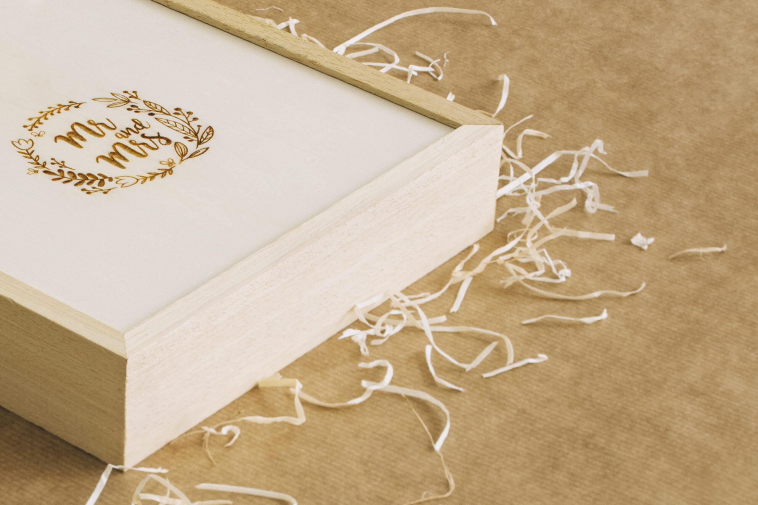 Custom lock-corner mailer box with gold foil logo and protective paper shred fill by Artsy Packaging UK