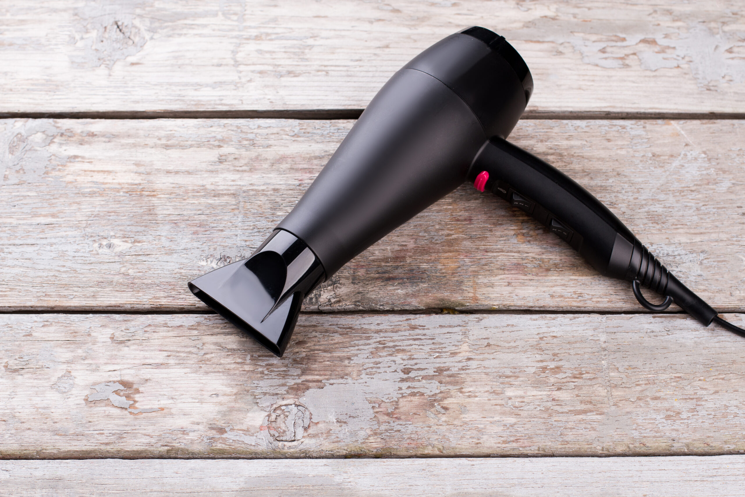 black hair dryer on wooden background 2026 03 09 05 39 47 utc