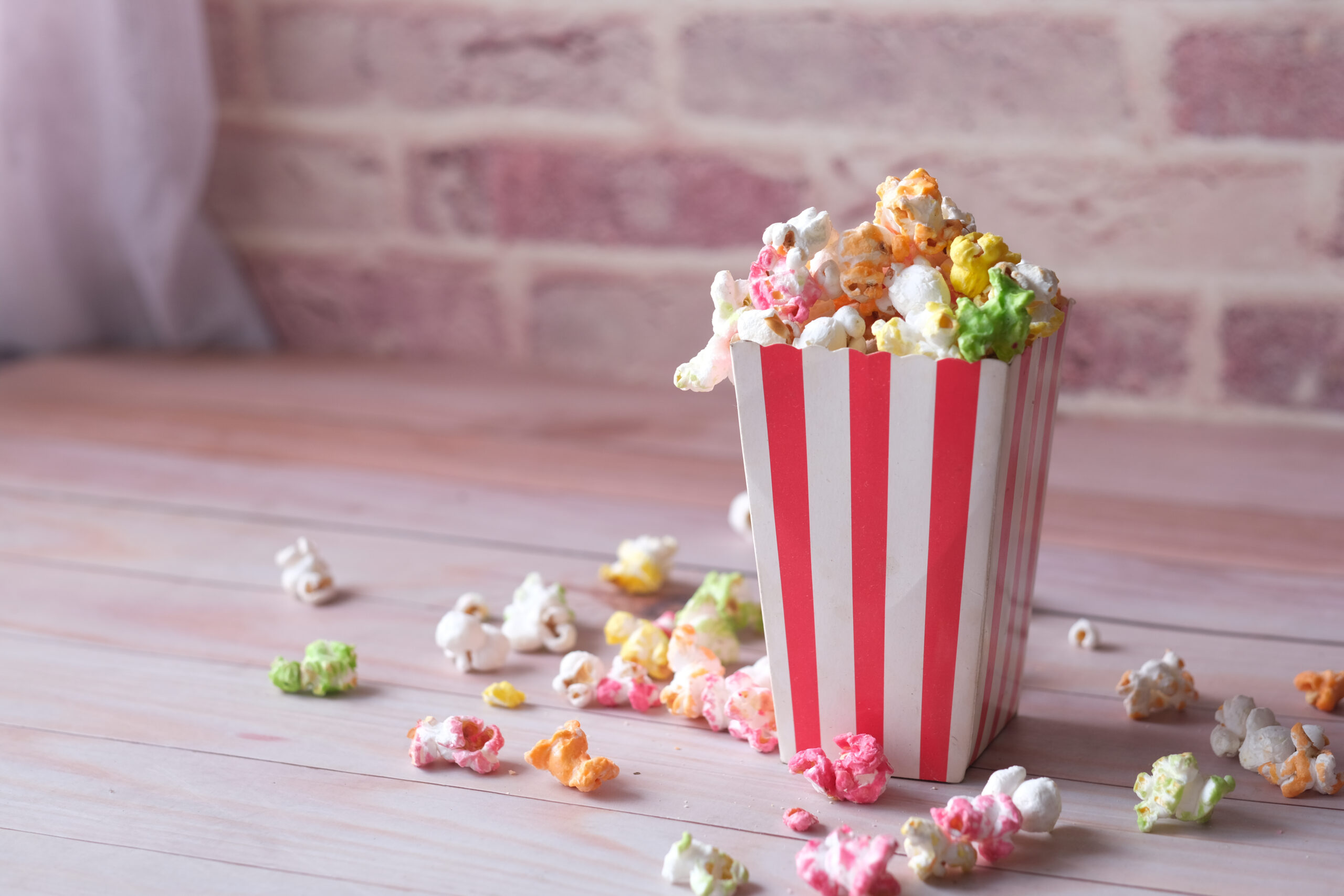 popcorn spilling from a paper container on wooden 2026 01 07 01 25 45 utc