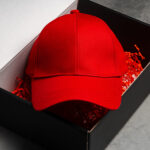 red baseball cap in cardboard box close up 2026 01 08 22 33 00 utc