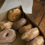 a box of assorted donuts on a wooden table ready f 2026 01 09 08 25 08 utc