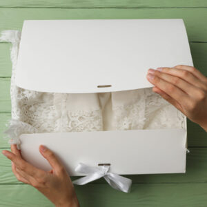 box with wedding dress and female hands on green b 2026 01 09 07 46 11 utc