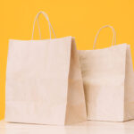 craft paper bags on wooden table against yellow ba 2026 01 08 01 13 06 utc