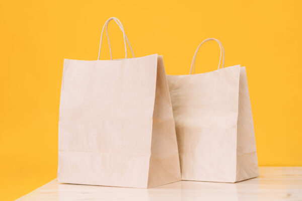 craft paper bags on wooden table against yellow ba 2026 01 08 01 13 06 utc
