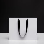 one white shopping bag on white table isolated on 2026 01 06 00 44 04 utc