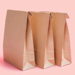 three brown paper bags on pink background side vie 2026 01 07 02 26 17 utc