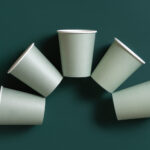 disposable light green paper cups on a dark green 2026 03 24 05 59 40 utc