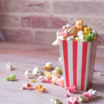 popcorn spilling from a paper container on wooden 2026 01 07 01 25 45 utc