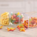 tasty gummy candies in glass jars on white marble 2026 01 11 11 08 32 utc
