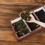 top view of dry tea on spoon and box on wooden sur 2026 01 06 00 17 33 utc