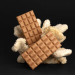 two large chocolate bars on a coral on black backg 2026 01 07 05 58 29 utc