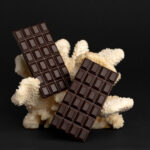 two large chocolate bars on a coral on black backg 2026 03 16 05 05 52 utc