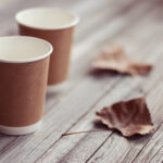 two paper cups standing on wooden table in outdoor 2026 03 17 00 26 56 utc