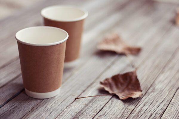 two paper cups standing on wooden table in outdoor 2026 03 17 00 26 56 utc