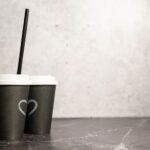 two paper cups with coffee on a black background 2026 03 13 05 40 30 utc