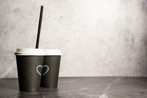 two paper cups with coffee on a black background 2026 03 13 05 40 30 utc