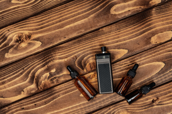 vape and vape juice bottles on brown wooden backgr 2026 01 08 07 11 31 utc