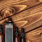 vape and vape juice bottles on brown wooden backgr 2026 01 08 22 39 39 utc