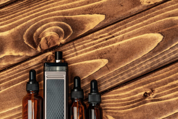 vape and vape juice bottles on brown wooden backgr 2026 01 08 22 39 39 utc