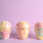yummy cotton candy in plastic cups on color backgr 2026 03 01 20 33 26 utc