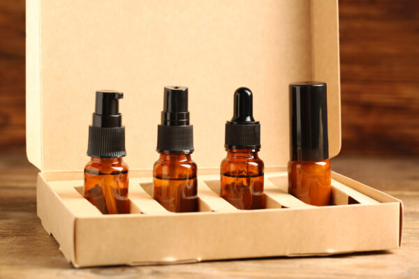 bottles with oil in box on wooden table closeup 2026 03 27 01 38 21 utc