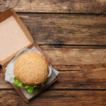 delicious burger in cardboard box on wooden table 2026 01 16 16 55 27 utc