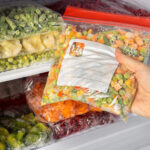 female hands retrieving frozen vegetable mix from 2026 02 04 19 50 11 utc