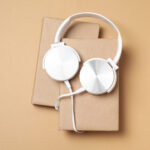 headphones on books on beige background top view 2026 03 24 21 37 09 utc