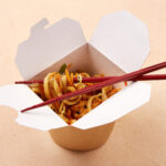 noodles served in takeout box with chopsticks on a 2026 03 27 00 47 52 utc (1)