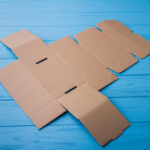 onfolded beige cardboard box on a blue wood 2026 03 09 04 32 18 utc