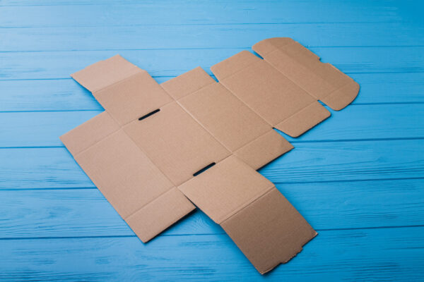 onfolded beige cardboard box on a blue wood 2026 03 09 04 32 18 utc