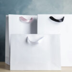 paper shopping bags on table against color backgro 2026 03 27 01 53 22 utc