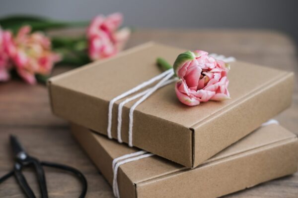 pink flower and wrapped boxes on a wood table 2026 03 17 05 04 21 utc