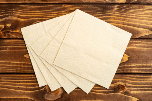 stack of paper square napkins on brown wooden back 2026 01 08 05 31 25 utc