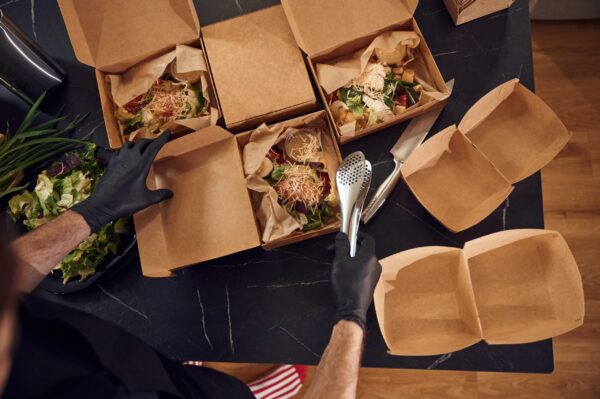 top view man is packing food into the paper eco b 2026 03 24 07 06 24 utc
