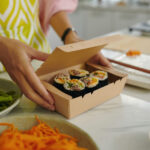 woman packing sushi in carton box 2026 01 08 00 10 16 utc