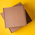 beige cardboard boxes on yellow background close 2026 01 08 22 41 55 utc