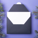 dark envelope with white card and evergreen sprigs 2026 03 17 08 59 08 utc