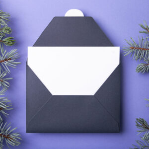 dark envelope with white card and evergreen sprigs 2026 03 17 08 59 08 utc