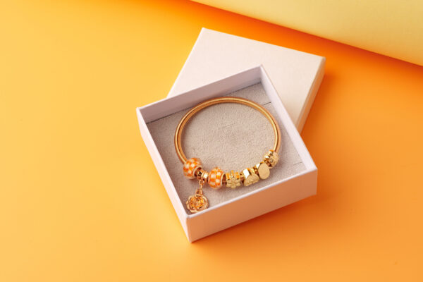 elegant gold charm bracelet in a white box 2026 03 24 01 26 49 utc