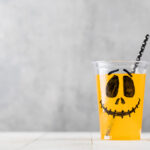 halloween drink with spooky face on white table 2026 03 19 04 19 34 utc
