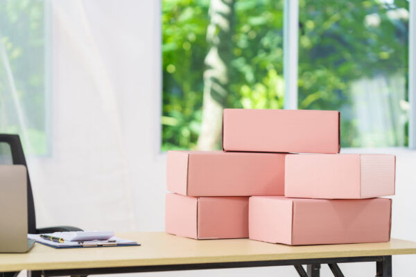 stacked pink boxes on a desk by a window 2026 03 18 17 43 56 utc
