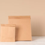 two tan paper bags on a white surface 2026 03 08 23 04 37 utc