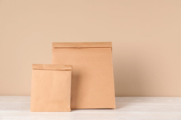 two tan paper bags on a white surface 2026 03 08 23 04 37 utc